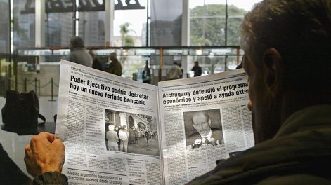 Una persona lee un diario en 2002 en plena crisis económica. Foto: AFP