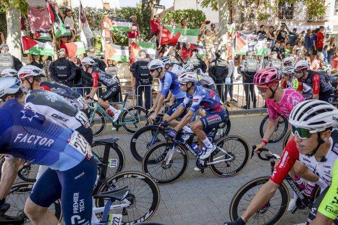 Los corredores del equipo Israel Premier Tech pasan delante de la manifestación propalestina, durante la última etapa de la Vuelta a España.