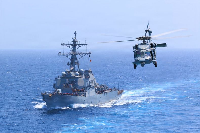 El USS Donald Cook navega por el mar Arábigo mientras un helicóptero MH-60S Sea Hawk sobrevuela la zona durante el bloqueo naval que Estados Unidos mantiene sobre Irán.