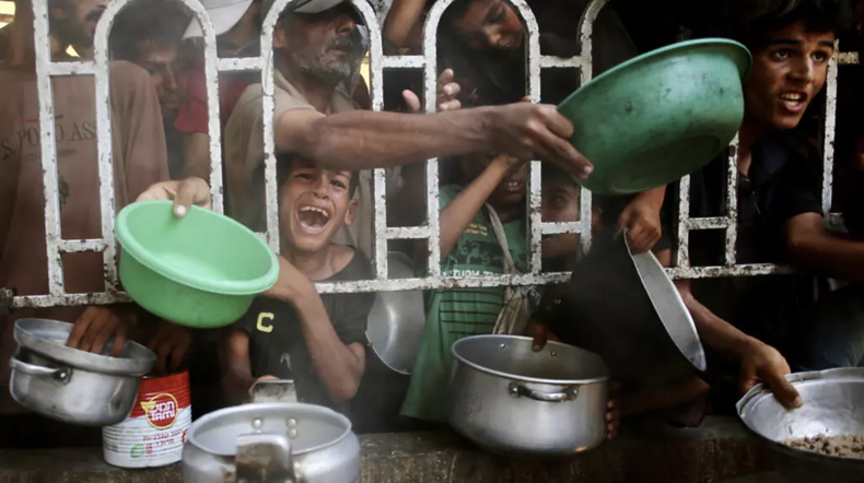 Palestinos esperan recibir comida en la zona de Al Mawasi, en el sur de la Franja de Gaza, el 22 de julio de 2025