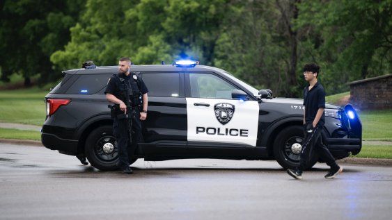 Un agente de policía de Brooklyn Park observa mientras custodian la entrada a un vecindario el 14 de junio de 2025 en Brooklyn Park, Minnesota