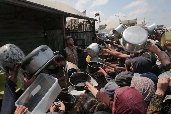 &nbsp;Palestinos muestran sus ollas vacías frente a un comedor social en Khan Yunis, al sur de la Franja de Gaza, el 21 de agosto de 2025.