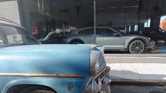 Coche viejo y coche de lujo, un contraste en una automotora del barrio Palermo