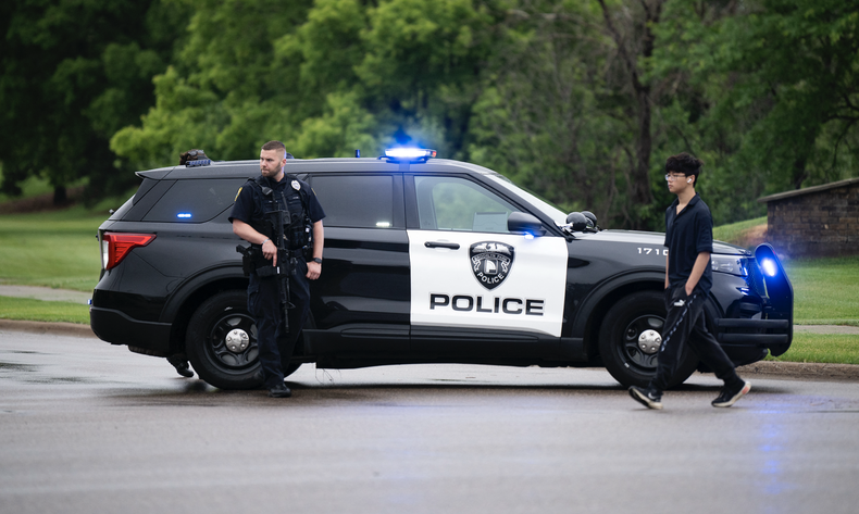 Un agente de policía de Brooklyn Park observa mientras custodian la entrada a un vecindario el 14 de junio de 2025 en Brooklyn Park, Minnesota
