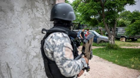 Un oficial de la Policía Nacional custodia una esquina durante un operativo contra bandas de narcotráfico en el barrio Villa Española.&nbsp;