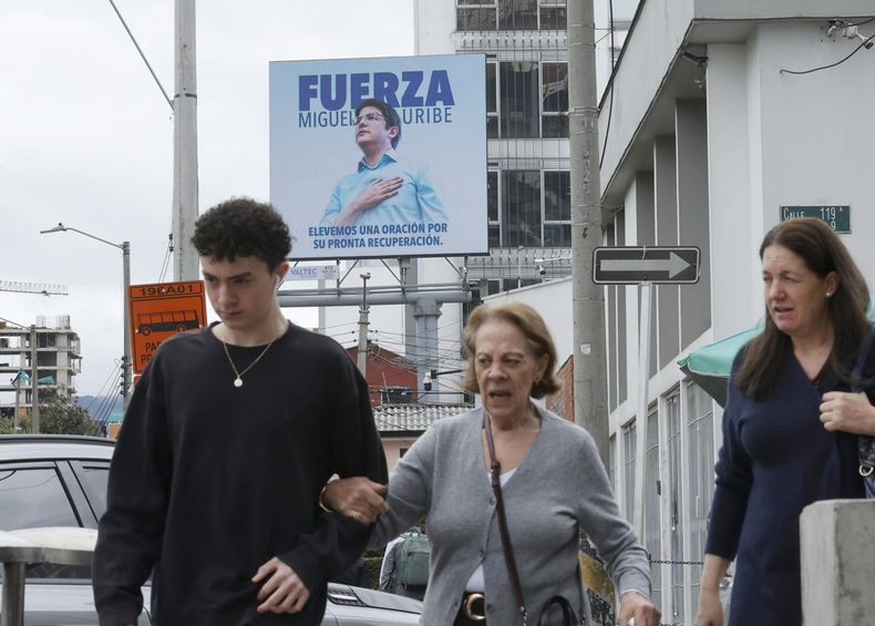 Personas caminan frente a una valla publicitaria del senador y precandidato presidencial colombiano Miguel Uribe Turbay, este miércoles en los alrededores de la Fundación Santa Fe de Bogotá (Colombia)