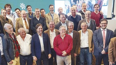 El presidente de la República, Luis Lacalle Pou, el ministro interino del Ministerio de Ganadería, Agricultura y Pesca (MGAP), Ignacio Buffa, el presidente del Banco República, Salvador Ferrer, y el presidente del Instituto Nacional de Carnes, Conrado Ferber, con los socios de Plaza Rural