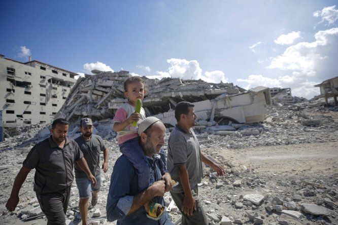 Palestinos caminan por una calle entre los escombros de edificios destruidos durante un alto el fuego entre Israel y Hamás, en virtud de la primera fase del plan de paz de Gaza, en la ciudad de Gaza, el 10 de octubre de 2025.