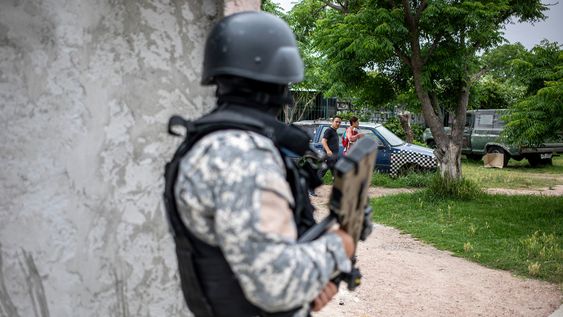 Un oficial de la Policía Nacional custodia una esquina durante un operativo contra bandas de narcotráfico en el barrio Villa Española.&nbsp;
