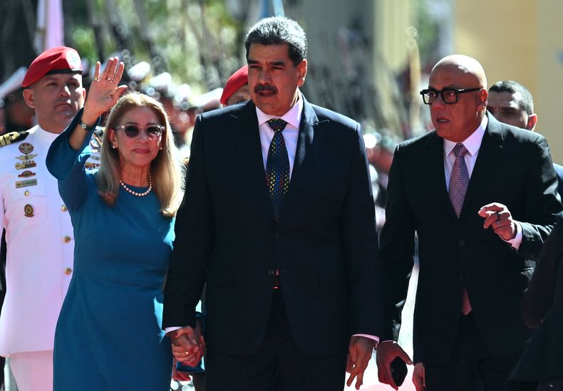 El presidente de Venezuela, Nicolás Maduro (centro), la primera dama Cilia Flores (i), y el presidente de la Asamblea Nacional, Jorge Rodríguez, caminan a su llegada al Capitolio, sede de la Asamblea Nacional, para la toma de posesión presidencial, en Caracas.