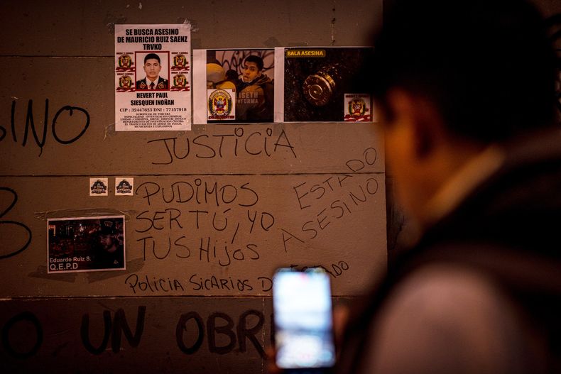 Una persona observa un muro con carteles durante una velatón este jueves, en homenaje a Eduardo Ruiz Saenz, quien falleció el miércoles durante las manifestaciones contra el Gobierno y el Congreso de Perú, en Lima (Perú).