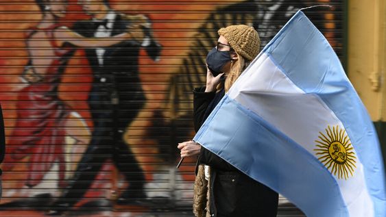 Una mujer sostiene una bandera argentina durante una protesta contra las políticas del presidente de Argentina, Alberto Fernández. Foto: AFP.