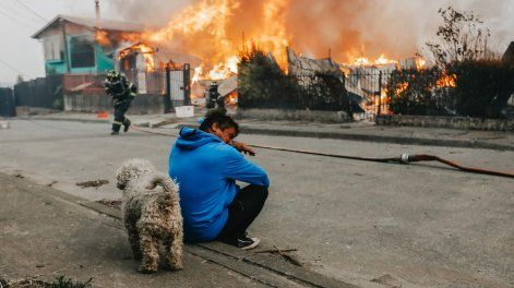Un hombre observa casas afectadas por incendios forestales este domingo, en Penco (Chile).