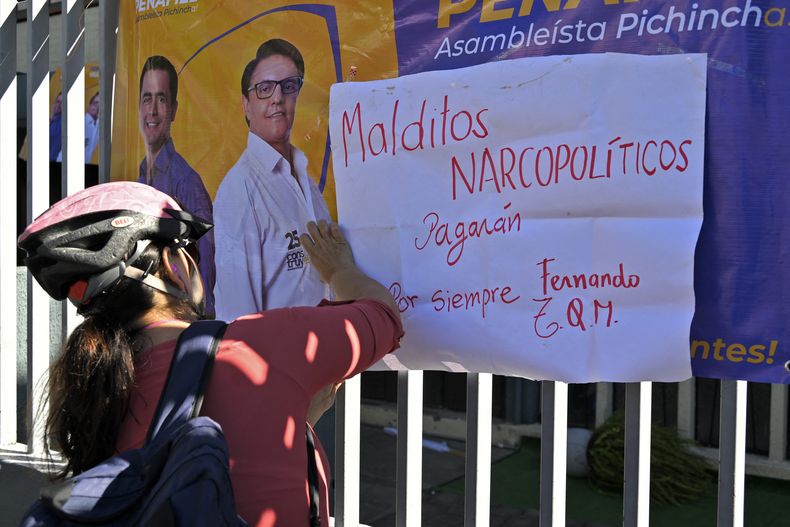 Un ciclista cuelga una pancarta contra la narcoviolencia en la reja del complejo deportivo donde fue asesinado el candidato presidencial ecuatoriano Fernando Villavicencio, el 10 de agosto de 2023.