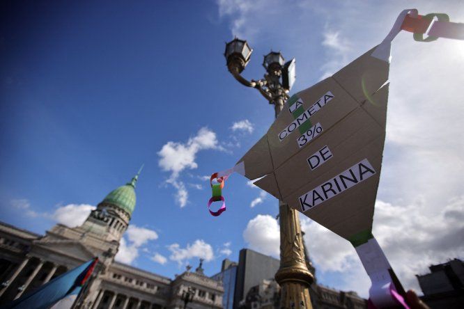 Una manifestante sostiene una pancarta que hace referencia a Karina Milei y su presunta participación en un escándalo de corrupción en el organismo público de discapacidad, frente al Congreso en Buenos Aires el 4 de setiembre de 2025.
