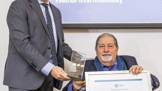 El ministro Da Silveira le entrega el reconocimiento a Danilo Arbilla. Foto: Lucía Durán