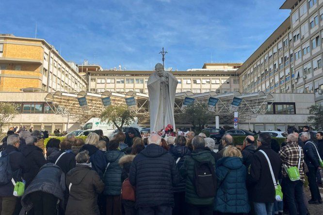 Un grupo de peregrinos de una parroquia de Turín reza frente al hospital Gemelli de Roma donde permanece ingresado el papa Francisco.