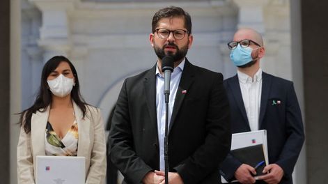 Giorgio Jackson e Izkia Siches escuchan a Gabriel Boric durante la presentación del gabinete. Foto: AFP