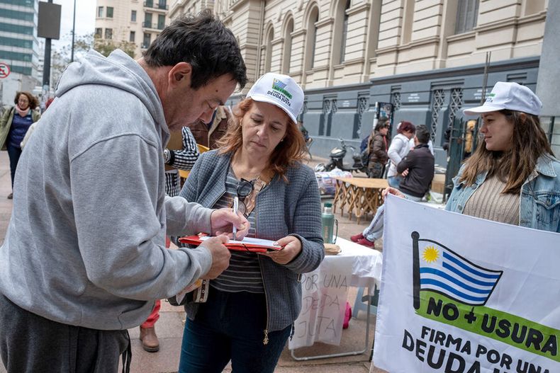 Militantes del plebiscito No más Usura-Por una Deuda Justa, impulsado por el partido Cabildo Abierto, recogen firmas en Av. 18 de Julio. Foto: Ricardo Antúnez