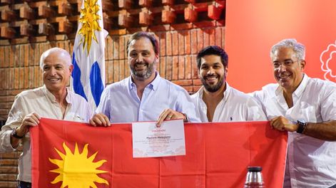 Marcelo Malaquina (segundo desde la izquierda), candidato a la Intendencia de Salto, recibe el pabellón colorado de parte de las autoridades partidarias