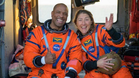 El piloto de la misión Artemis II, el astronauta Victor Glover (i), y la especialista de misión, la astronauta Christina Koch (d), saludando desde un helicóptero MH-60 Seahawk de la Armada estadounidense tras salir de la nave espacial Orion este viernes, en el océano Pacífico, frente a la costa de California (Estados Unidos).