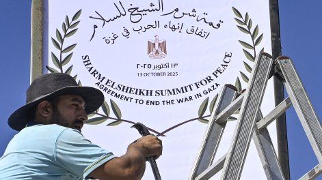 Un trabajador municipal coloca un cartel en Sharm el-Seij, mientras la ciudad turística egipcia se prepara para albergar una cumbre de paz en Gaza, mediada por Estados Unidos, el 12 de octubre de 2025.