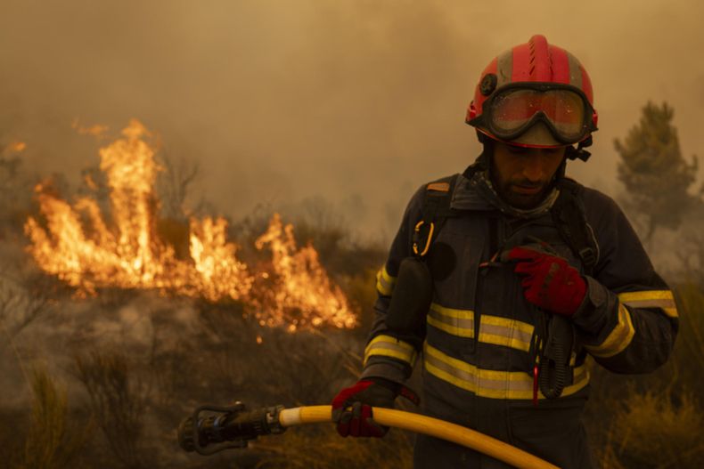 Vecinos y bomberos intentan aplacar el fuego que afecta este viernes a la aldea de Lamas (Cualedro), en Ourense