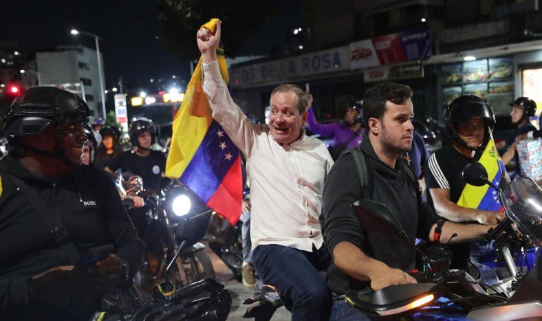 El opositor Juan Pablo Guanipa (c) sostiene una bandera de Venezuela en una manifestación este domingo, en Caracas (Venezuela).