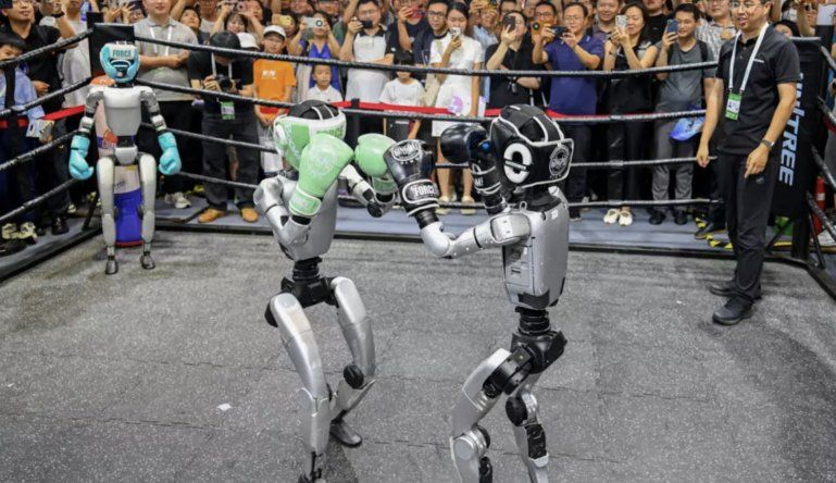 La gente observa a robots humanoides boxeando en una exhibición durante la Conferencia Mundial de IA en Shanghái, en julio de 2025