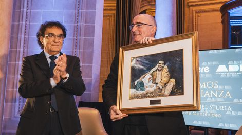 Presidente de ADM Jorge Abuchalja entrega un cuadro al cardenal y arzobispo de Montevideo Daniel Sturla.