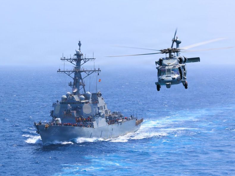 El USS Donald Cook navega por el mar Arábigo mientras un helicóptero MH-60S Sea Hawk sobrevuela la zona durante el bloqueo naval que Estados Unidos mantiene sobre Irán.