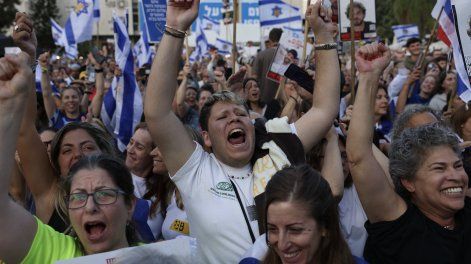 Los israelíes reaccionan mientras esperan la liberación de los israelíes aún retenidos en Gaza en la Plaza de Rehenes de Tel Aviv la madrugada del 13 de octubre de 2025.
