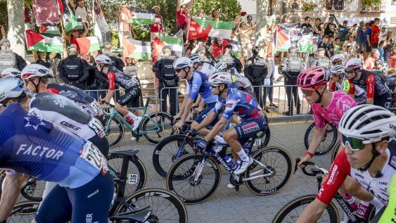 Los corredores del equipo Israel Premier Tech pasan delante de la manifestación propalestina, durante la última etapa de la Vuelta a España.