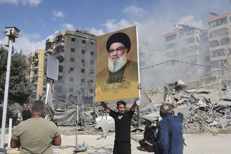 Una persona sostiene una pancarta del líder de Hezbolá, Hassan Nasrallah, junto a los escombros de un edificio completamente destruido en Dahieh, un suburbio del sur de Beirut (Líbano), 2 de octubre de 2024