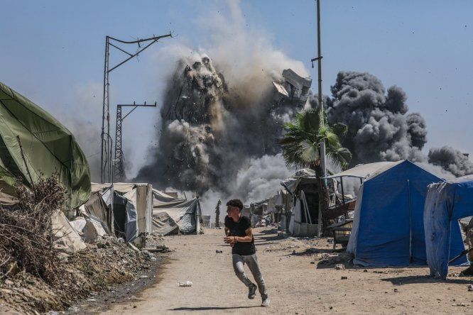 Un niño corre mientras la Torre Mushtaha se derrumba tras un ataque aéreo israelí en el oeste de la ciudad de Gaza, Franja de Gaza, el 5 de septiembre de 2025.
