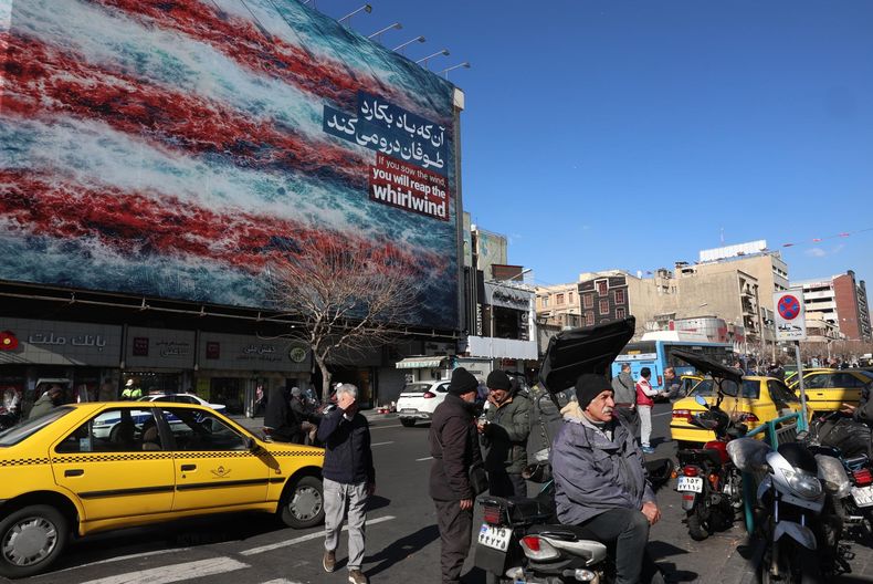 Iraníes caminan cerca de una enorme valla publicitaria antiestadounidense en la plaza Enqelab de Teherán, Irán, el 31 de enero de 2026.