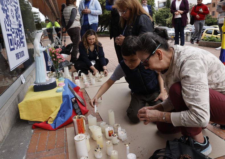 Personas ponen velas junto a una virgen en honor al senador y precandidato presidencial colombiano Miguel Uribe Turbay este martes, en la Fundación Santa Fe de Bogotá (Colombia).&nbsp;