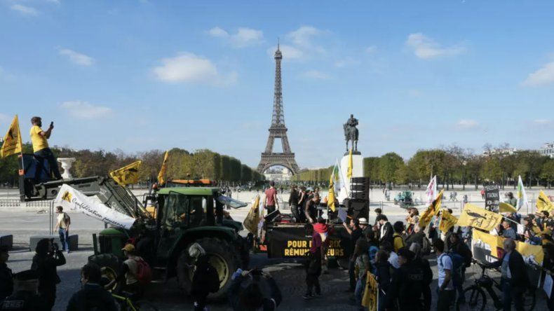 Manifestantes protestan contra el acuerdo de libre comercio entre la Unión Europea y el Mercosur, con la Torre Eiffel al fondo, en París, el 14 de octubre de 2025.