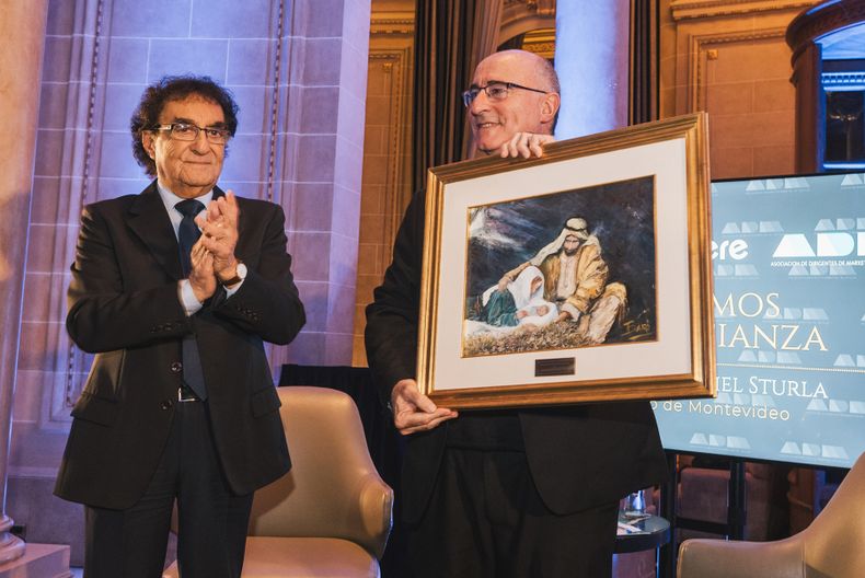 Presidente de ADM Jorge Abuchalja entrega un cuadro al cardenal y arzobispo de Montevideo Daniel Sturla.