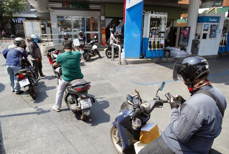 Motociclistas hacen cola para repostar en una estación de servicio de Bangkok, Tailandia, tras el estallido de la guerra en Irán.