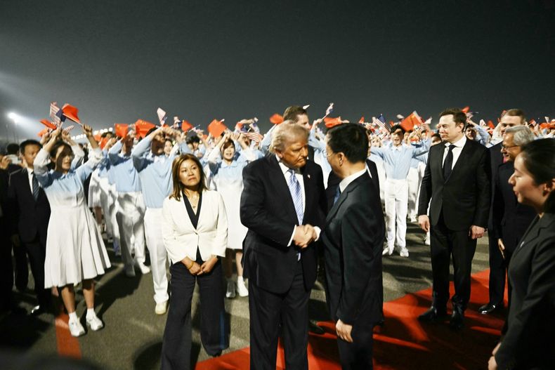 Donald Trump es recibido por el vicepresidente chino Han Zheng mientras el director ejecutivo de SpaceX, Twitter y el fabricante de automóviles eléctricos Tesla, Elon Musk, observa en el Aeropuerto Internacional de Pekín el 13 de mayo de 2026.