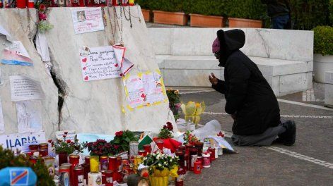 Una persona reza ante la estatua de Juan Pablo II en el exterior del Hospital Universitario Gemelli, donde el Papa Francisco está hospitalizado por neumonía, en Roma.