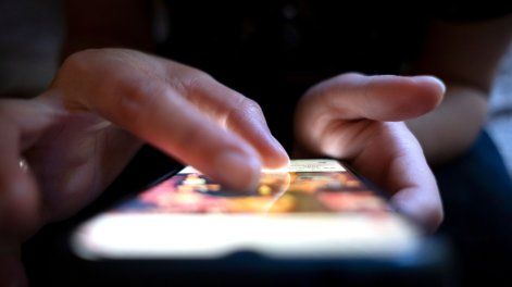 Joven usa un celular.