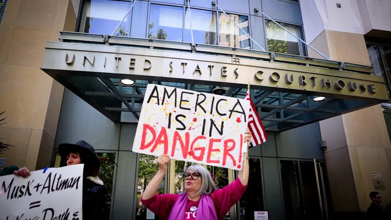 Manifestantes se congregan frente al juzgado Ronald V. Dellums durante un juicio entre Elon Musk y OpenAI en Oakland, California.