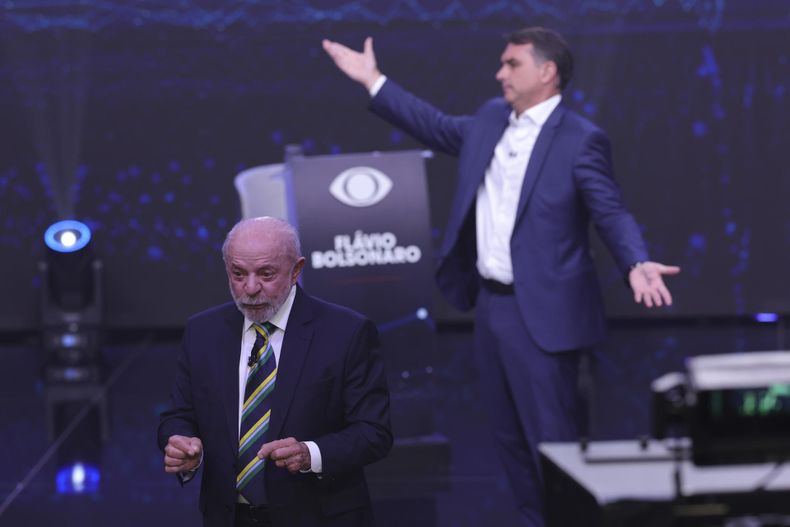 El presidente de Brasil y candidato a la reelección, Luiz Inácio Lula da Silva (i), y el opositor Flávio Bolsonaro, hablan en el primer debate presidencial el domingo 18 de octubre de 2026, en la sede de Rede Bandeirantes en Sao Paulo (Brasil).