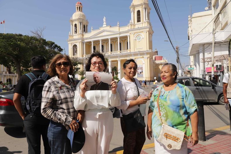 Una mujer muestra una foto donde aparece el papa León XIV este jueves, frente a la iglesia Santa María Catedral, en Chiclayo. Los católicos de Perú celebraron que se haya elegido a Robert Prevost como el papa León XIV