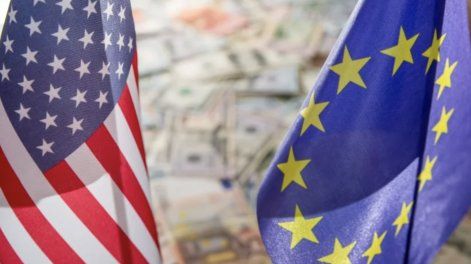 Banderas de Estados Unidos y la Unión Europea sobre dólares y euros.