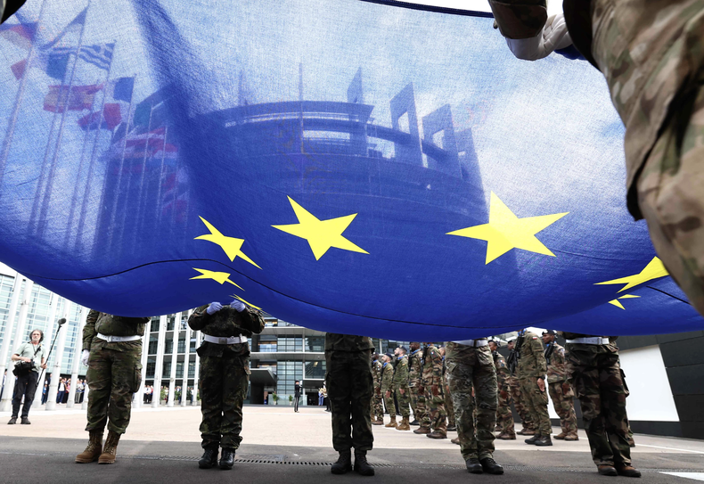 Soldados recogen una bandera de la Unión Europea en la sede de Bruselas.