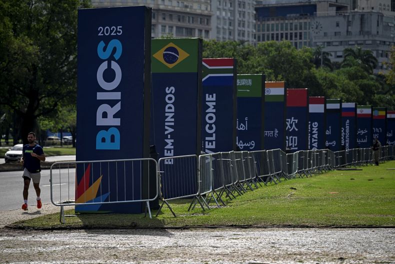 Un hombre corre junto a las pancartas de la cumbre BRICS en los alrededores del Museo de Arte Moderno (MAM), donde se celebrará la cumbre BRICS 2025 en Río de Janeiro