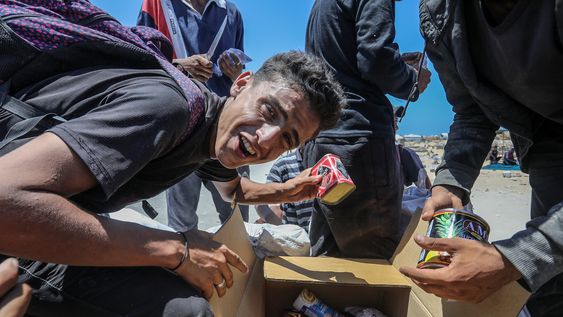 Un residente de Gaza recibe una lata de comida en medio de la aguda crisis alimentaria que vive el territorio palestino y que numerosas organizaciones y gobiernos achacan a Israel Un residente de Gaza recibe una lata de comida en medio de la aguda crisis alimentaria que vive el territorio palestino y que numerosas organizaciones y gobiernos achacan a Israel